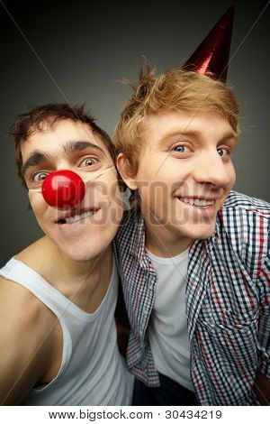 zwei lustige Typen Blick auf die Kamera und lächelnd verrückt, des Dummkopfs Tages Serie oder Geburtstag feiern