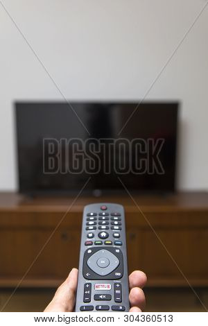 Belgrade, Serbia - May 9, 2019: Hand Holding An Netflix Remote Control. Netflix Is An American Media