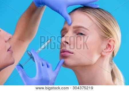 Face Of A Girl With Smooth Skin Without Wrinkles Makes Beauty Shots. Syringe Next To The Face, Skin 