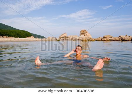 ชายหนุ่มมาขึ้นจากน้ำและเจรจาบนมือถือ