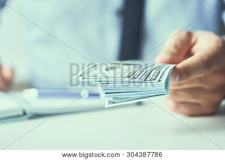 Man Giving Money Us Dollar Banknotes And Holding Cash In Hands. Money Credit Concept. Toned Picture.