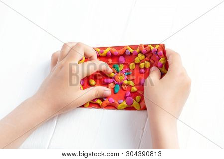 A Child Kneads Plasticine And Sculpts A Juicy, Bright Multi-colored Rug. Tutoring With Children.
