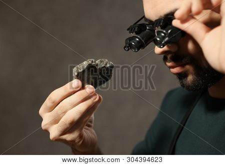 Male Jeweler Evaluating Semi Precious Gemstone In Workshop, Closeup