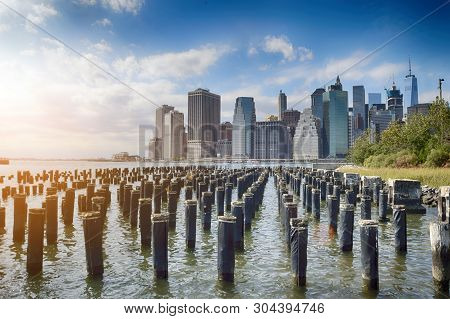Old Pier Pylons And Downtown Manhattan, New York City.