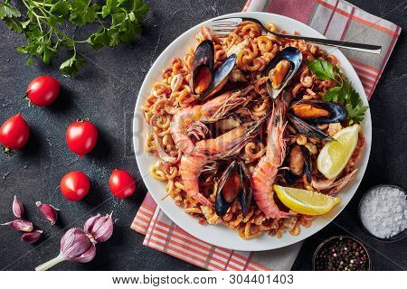 Spanish Fideua, A Noodle Paella With King Prawns, White Fish Meat, Calamari, Mussels Served On A Whi