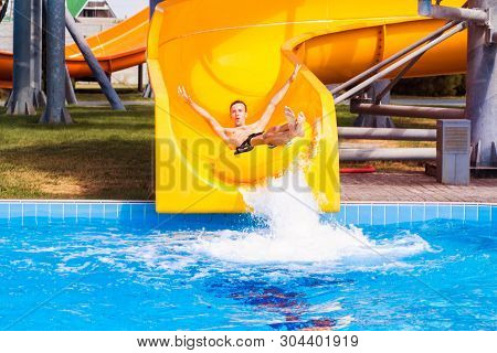 Funny Excited Man Enjoying Summer Vacation In Water Park Riding Yellow Float Laughing.