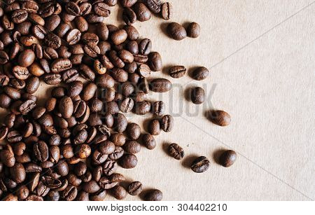 Coffee Beans On Braun Background With Place For Text.