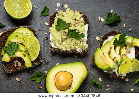 Sandwiches With Avocado And Cream Cheese With Grain Bread And Seeds. Black Slate Background, Top Vie
