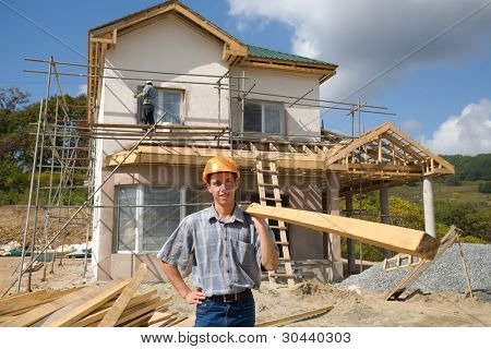 O jovem Construtor detém uma madeira madeira.