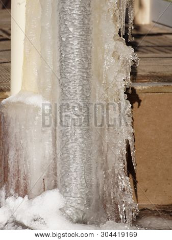 Ice And Icicles On A Drainpipe. Drainpipe Covered With Ice And Icicles.