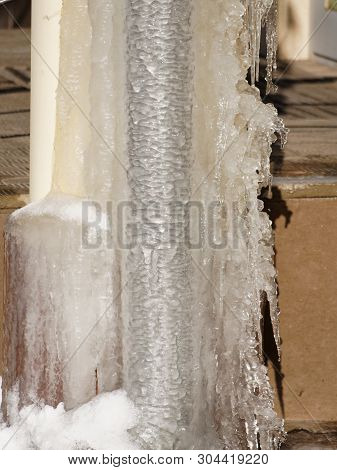 Ice And Icicles On A Drainpipe. Drainpipe Covered With Ice And Icicles.