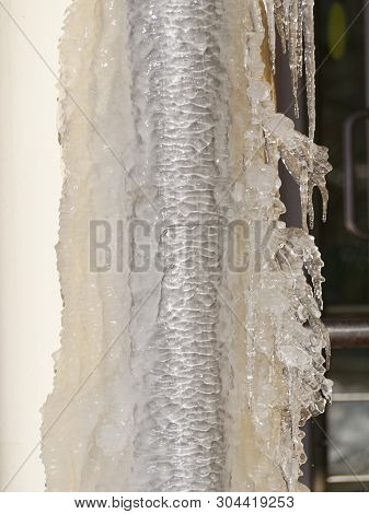 Ice And Icicles On A Drainpipe. Drainpipe Covered With Ice And Icicles.