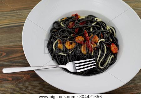 Italian Black Spaghetti, Alla Veneziana, With Grilled Prawns And Dried Tomatoes. With Olive Oil, Gar