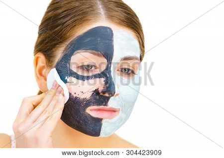 Woman With Clay Carbo Black Mask On One Half Face And White Mud On Second Half. Girl Removing Cosmet