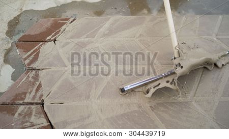 Mop Clean Pavement Tiles.. The Master Tile Smears The Mucilage Solution On The Tile.