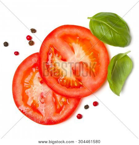 Slices of tomato and basil leaves isolated on white background. Top view, flat lay.