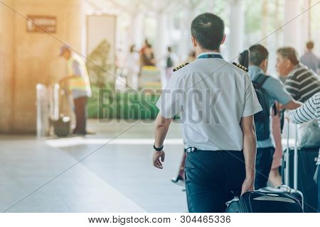 Steward With Big Roller Luggage Stand To Wait For The Car To Pick Up At Airport Arrival Terminal.