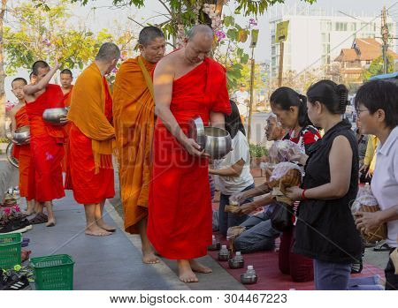 Lampeng, Tahiland - 2019-03-07 - Line Of Monks Receive Gifts Of Food From Worshippers Along Street.