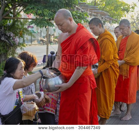 Lampeng, Tahiland - 2019-03-07 - Line Of Monks Receive Gifts Of Food From Worshippers Along Street.