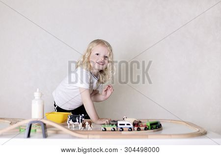 Little Cute Baby Boy (3 Years Old) Drinks Milk With Cookies And Plays In The Wooden Station Train Se
