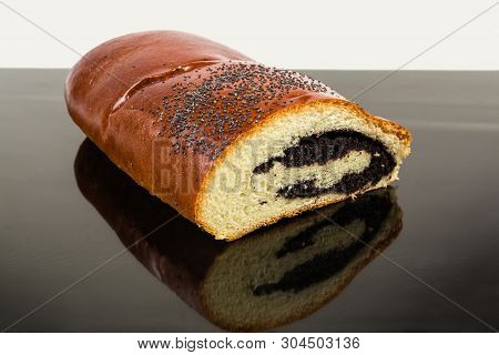 Piece Of The Pie With Sweet Crushed Poppy Seed Filling And Sprinkled With Whole Poppy Seeds On A Dar