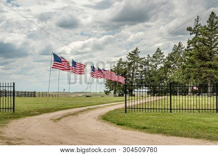 Memorial Day celebration - a  row of American flags on a rural cemetery in Nebraska Sandhills