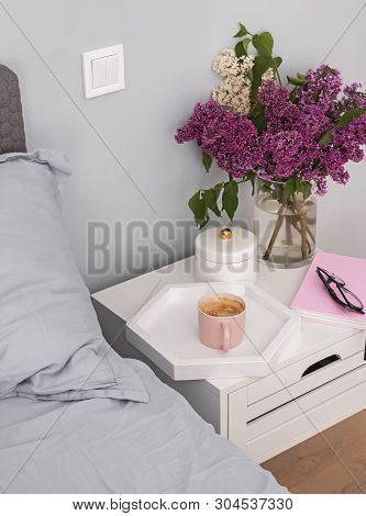 Coffee And Flowers Standing On The Nightstand Near The Bed.
