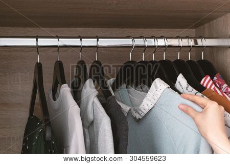 Girl Chooses Clothes For The Day From Wardrobe, Closeup