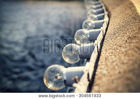 Incandescents Or Light Bulbs In A Row On Wall Edge