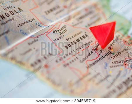 World Map With Focus On Republic Of Botswana With Red Triangle Pin On Capital City Gaborone.