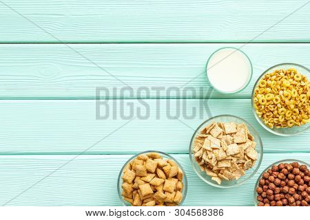 Cereals, Oatflakes And Cornflakes With Milk For Healthy Breakfast On Mint Wooden Background Top View