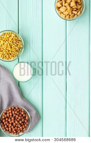 Cereals, Oatflakes And Cornflakes With Milk For Healthy Breakfast On Mint Wooden Background Top View