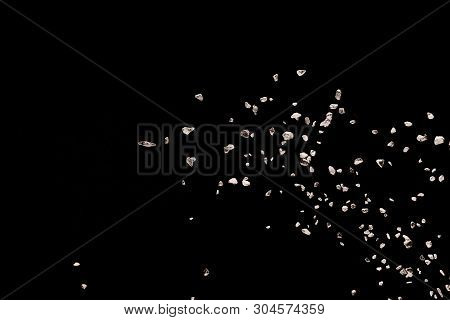 Split Debris Of Stone Exploding Against Black Background.