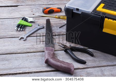 Tool Box And Various Construction Instruments On Wooden Surface. Pliers, Saw, Spanner, Allen Keys, S