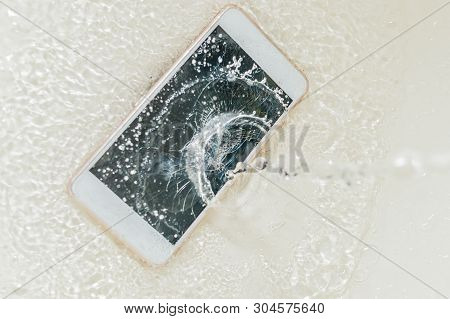 Phone Dropped Into The Water. Telephone And Water Spra