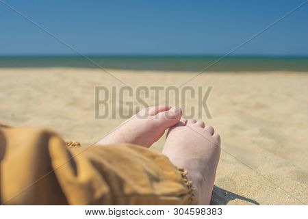 Bare Children's Feet On The Beach. Close-up