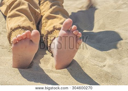 Bare Children's Feet On The Beach. Close-up