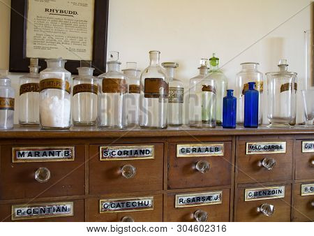 North Wales, Uk 4th Sept 2018 Old Clear And Blue Glass, Medicine Bottles On Drawer Cabinet With Labe