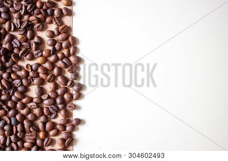 Coffee Beans On Braun Background With Place For Text.