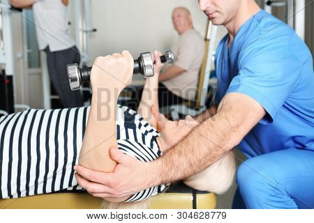 Patient Exercising Under Physiotherapist Supervision In Rehabilitation Center