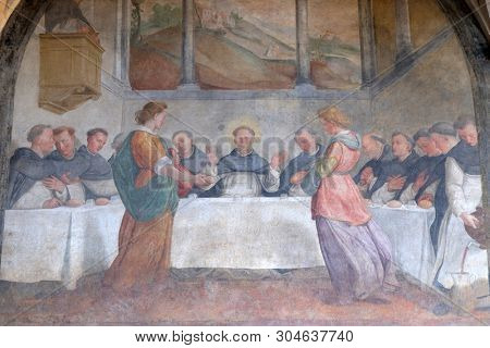 FLORENCE, ITALY - JANUARY 10, 2019: San Dominic in Mensa fed by the Angels, fresco by Santi di Tito in the cloister of Santa Maria Novella Principal Dominican church in Florence, Italy