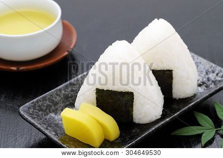 Onigiri. Rice Triangle With Nori Seaweed On White Plate