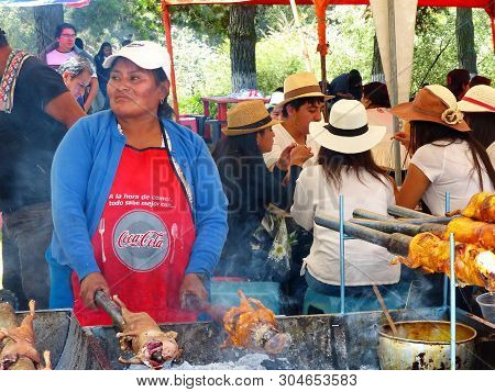 Cuenca, Ecuador - April 11, 2018: Vendor Woman Prepares Cuy Or Roasted Guinea Pig - Traditional Deli