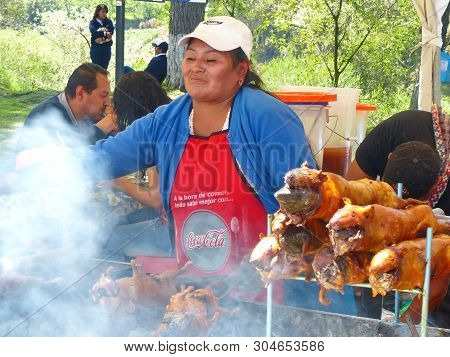 Cuenca, Ecuador - April 11, 2018: Vendor Woman Prepares Cuy Or Roasted Guinea Pig - Traditional Deli