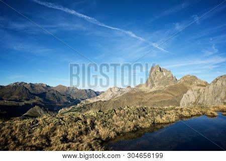 Midi Dossau Peak reflected in a lake. Ossau Valley, Pyrenees National Park, Pyrenees, France.