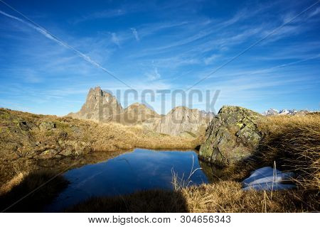 Midi Dossau Peak reflected in a lake. Ossau Valley, Pyrenees National Park, Pyrenees, France.