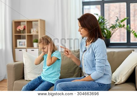 misbehavior, conflict and family concept - angry mother scolding her daughter at home
