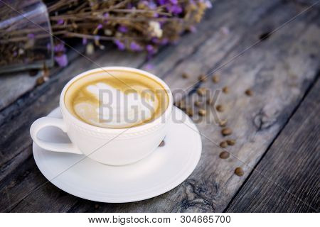 Coffee Cup On Wood And Vaes Flower Background.