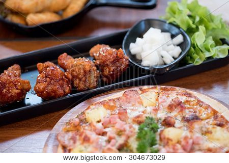 Spicy Korean Sauce Coated With Sesame On Fried Chicken Drumlets Served With Delicious Hot Pizza On W