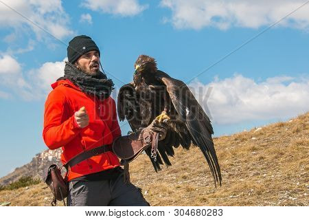 Rocca Calascio, Italy - March 3, 2019: Portrait Of Man With Big Golden Eagle At The Festival Of Eagl